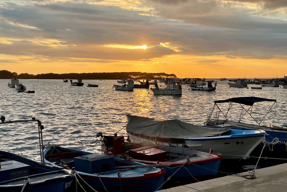 Zee - ondergaande zon - Porto Cesareo - vissersbootjes