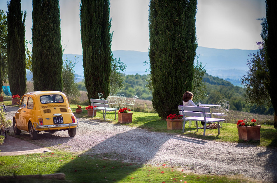 Mooiste plekken van Italië: dit is onze top 10 -Toscaanse heuvels - cipressen - Fiat 500 - bankjes met lezende vrouw