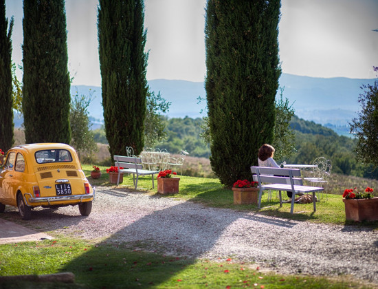 Mooiste plekken van Italië: dit is onze top 10 -Toscaanse heuvels - cipressen - Fiat 500 - bankjes met lezende vrouw
