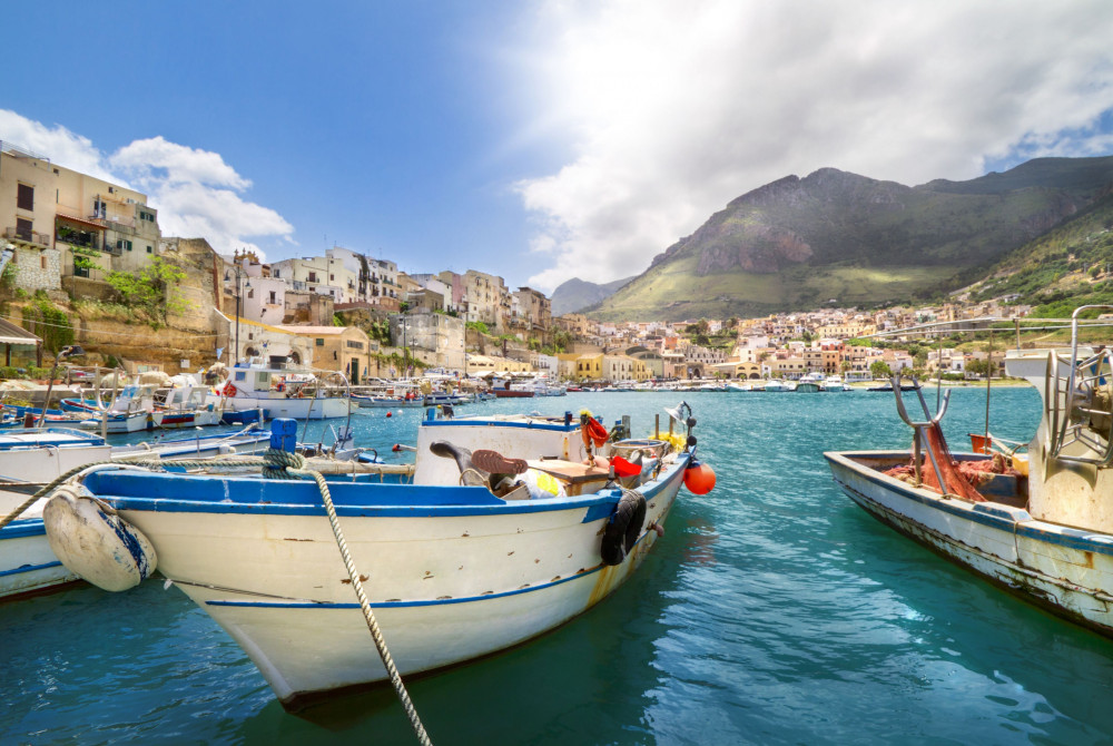 Ontdek wat er te doen is in Noordwest-Sicilië - vissersbootjes op de zee - San Vito La Capo in achtergrond